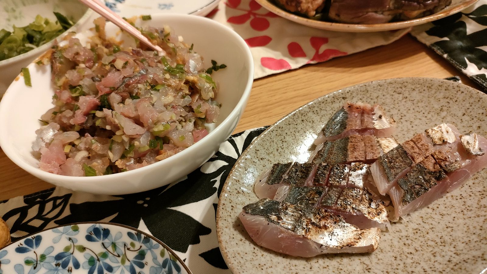 釣ったアジのなめろうを飯にのせた丼と、皮目を炙ったたたきの皿。薬味のねぎ。